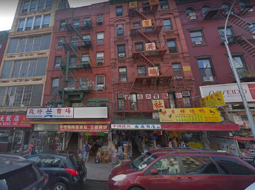 A modern photo of a row of brick tenement buildings in Chinatown, with 101 East Broadway indicated.