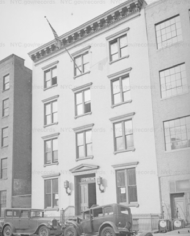 A black and white photo of the old East Twenty-Second Street police station, a brick institutional building from the 19th century.